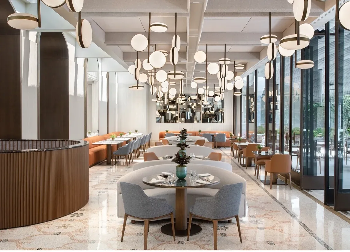 Licht restaurant met terrazzovloer en een wolk van bolvormige hanglampen