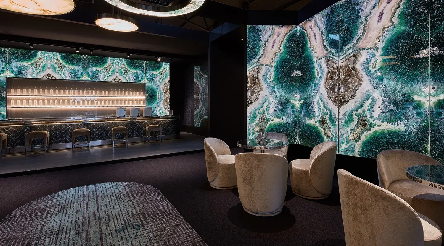 Lounge met verlichte bar en wanden van groen geode-marmer