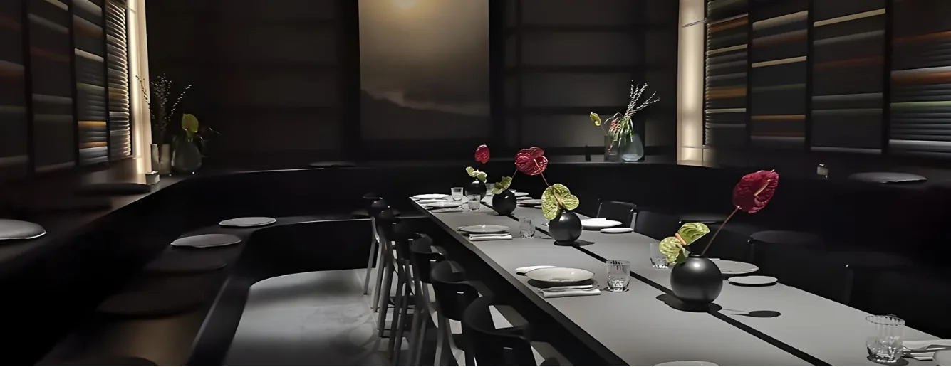 Verdiept private dining gedeelte met lange tafel en donkere, sfeervolle materialisatie
